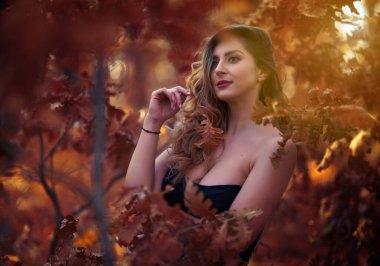 Sonbaharın sonlarında meşe ormanında güzel seksi bir kadın.