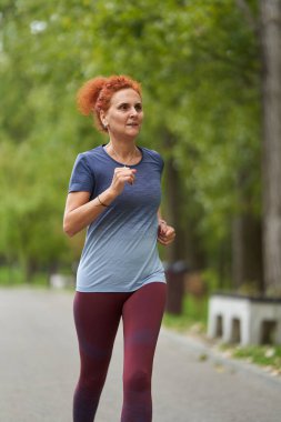 Sabahları sonbahar parkında koşan atletik kadın portresi 