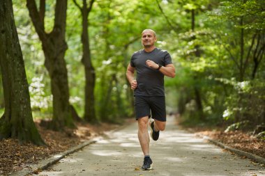 Yazın sabah parkta koşan atletik koşucu 