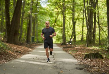 Yazın sabah parkta koşan atletik koşucu 