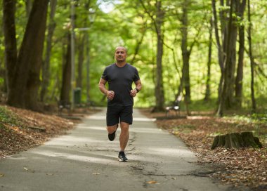 Yazın sabah parkta koşan atletik koşucu 