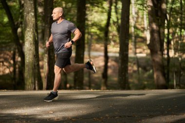 Atletik erkek koşucu yazın sonlarında sabah parkta.