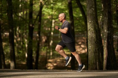 Atletik erkek koşucu yazın sonlarında sabah parkta.