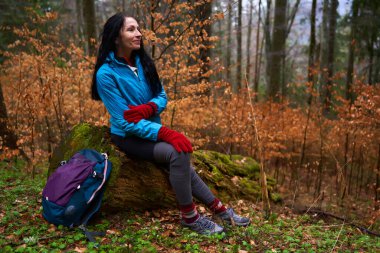 Yağmurlu bir günde sırt çantalı bir kadın ormanda yürüyüşe çıktı.