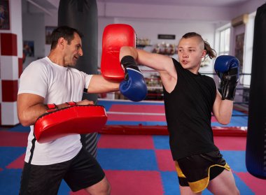 Genç kickboksçu antrenmanı Koçuyla kickboks salonunda