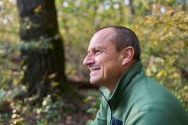 Gündüz vakti parkta kendini ifade eden olgun bir adamın portresi. 