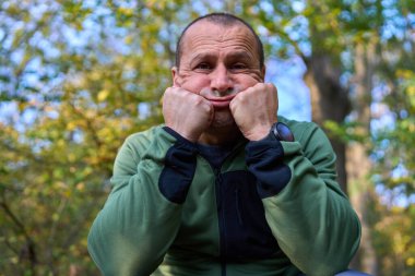 50 'li yaşlarda, değişik ifadeler sergileyen, etkileyici, olgun bir adamın yakın çekimi.