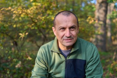 50 'li yaşlarda, değişik ifadeler sergileyen, etkileyici, olgun bir adamın yakın çekimi.