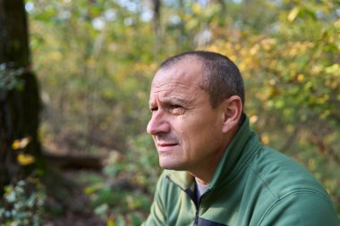 50 'li yaşlarda, değişik ifadeler sergileyen, kendini ifade eden, olgun bir adamın gündüz görüşü.