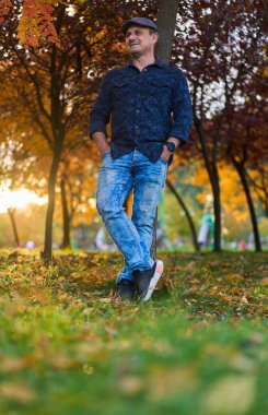 Gündüz vakti orta yaşlı bir adamın sonbahar parkında yürüyüşü 