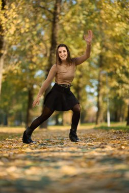 İspanyol kadın renkli sonbahar parkında eğleniyor. 