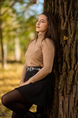 Ilık bir sonbahar günü etrafı ağaçlarla çevrili İspanyol bir kadın.