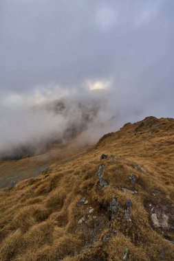 Soğuk bir kasım gününde kayalık dağların ve yürüyüş yollarının üzerindeki bulutlar