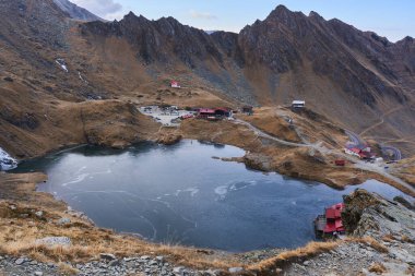 Buzul gölü, Chalet ve kulübeleri olan kayalık dağlar.
