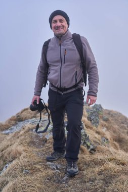 Kayalık dağlarda sırt çantalı bir yürüyüşçü.