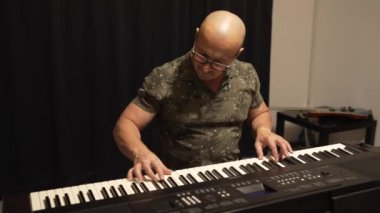 Piyano çalan orta yaşlı bir adam evde konsantrasyonunu ve yaratıcılığını ifade ediyor.