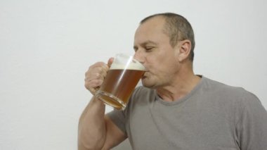 Mutlu orta yaşlı adam evde bira içiyor.