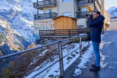 Kış başında İsviçre Alplerinde harika bir tatil yapan kameralı genç bir turist.