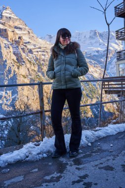 İsviçre Alpleri 'nin pitoresk bir yerinde kışlık ceketli genç bir turist.