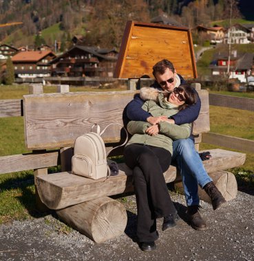 Genç turistler İsviçre Alplerinde yürüyüş yapıyor ve fotoğraf çekiyorlar.