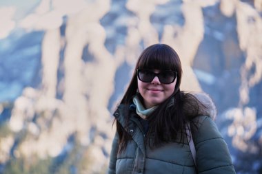 Genç bayan turist arkasında İsviçre Alpleriyle poz veriyor.