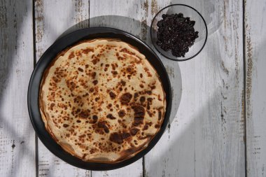 Tahtada vişne reçeli ve ince krep yığını.