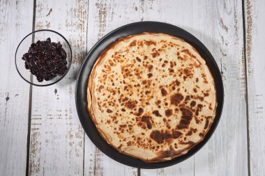 Tahtaya siyah kiraz reçeli konmuş ince krep yığını.