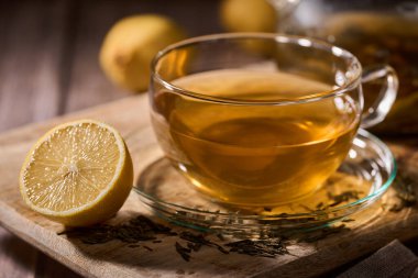 Japon Sencha çayını cam bardakta, kırsal bir tahta üzerinde cam çaydanlıkla yakından çek.