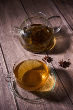 Japon Sencha çayını cam bardakta, kırsal bir tahta üzerinde cam çaydanlıkla yakından çek.