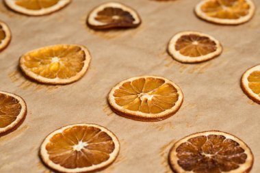 Kahverengi kabartma kağıdında kurumuş portakal dilimleri yakın plan.