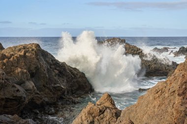 Güçlü okyanus dalgaları volkanik kayalara çarpıyor, Tenerife 'nin engebeli kıyı şeridinde dramatik bir püskürme yaratıyor.