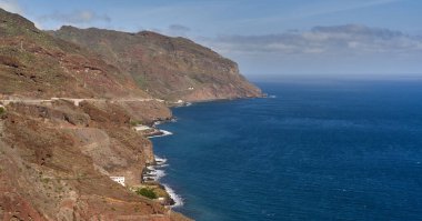 Tenerife 'deki derin mavi okyanusa bakan engebeli uçurumlar boyunca dolambaçlı kıyı yolu