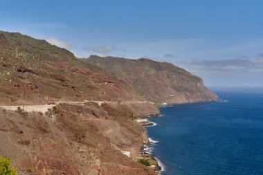 Tenerife 'deki derin mavi okyanusa bakan engebeli uçurumlar boyunca dolambaçlı kıyı yolu