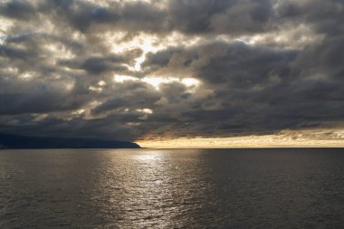 Gün batımında Atlantik Okyanusu üzerinde dramatik fırtına bulutları Tenerife, İspanya üzerinde altın ışık kırılıyor.