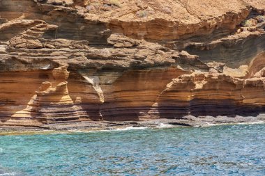 Tenerife 'deki Playa de Montana Amarilla' da okyanusun üzerindeki volkanik kayalıklar. 