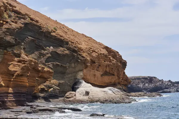 Tenerife 'deki Playa de Montana Amarilla' da okyanusun üzerindeki volkanik kayalıklar. 