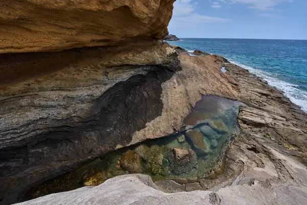Playa de Montana Amarilla, Tenerife 'de Atlantik Okyanusu' yla buluşan katmanlı kumtaşı kayalıkları