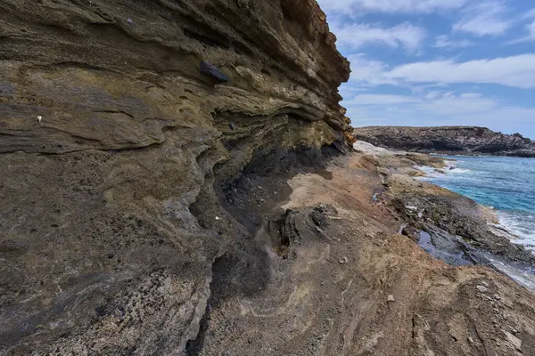 Playa de Montana Amarilla, Tenerife 'de Atlantik Okyanusu' yla buluşan katmanlı kumtaşı kayalıkları
