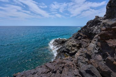 Tenerife 'deki Playa de Montana Amarilla yakınlarında volkanik kıyı şeridi ve okyanus dalgaları çarpışıyor. 