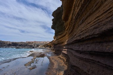 Tenerife 'deki Playa de Montana Amarilla' da okyanusun üzerindeki volkanik kayalıklar.