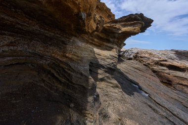Tenerife 'deki Playa de Montana Amarilla' da okyanusun üzerindeki volkanik kayalıklar.