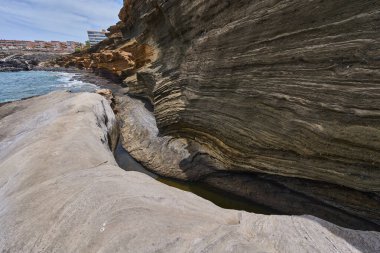 Tenerife 'deki Playa de Montana Amarilla' da okyanusun üzerindeki volkanik kayalıklar.