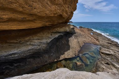 Tenerife 'deki Playa de Montana Amarilla' da okyanusun üzerindeki volkanik kayalıklar.
