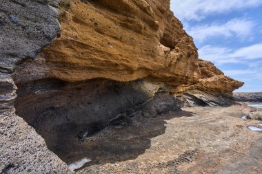 Tenerife 'deki Playa de Montana Amarilla' da okyanusun üzerindeki volkanik kayalıklar.