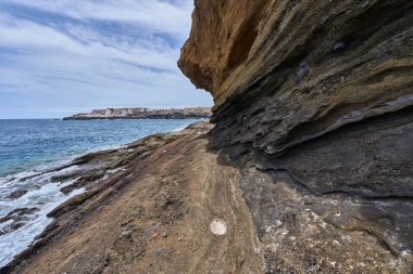 Tenerife 'deki Playa de Montana Amarilla' da okyanusun üzerindeki volkanik kayalıklar.