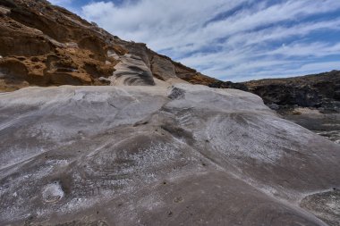 Tenerife 'deki Playa de Montana Amarilla' da okyanusun üzerindeki volkanik kayalıklar.
