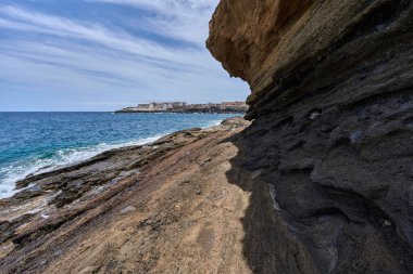 Tenerife 'deki Playa de Montana Amarilla' da okyanusun üzerindeki volkanik kayalıklar.