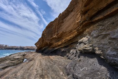 Tenerife 'deki Playa de Montana Amarilla' da okyanusun üzerindeki volkanik kayalıklar.