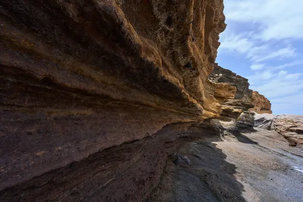 Tenerife 'deki Playa de Montana Amarilla' da okyanusun üzerindeki volkanik kayalıklar.