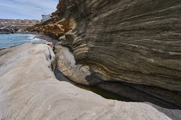 Tenerife 'deki Playa de Montana Amarilla' da okyanusun üzerindeki volkanik kayalıklar.